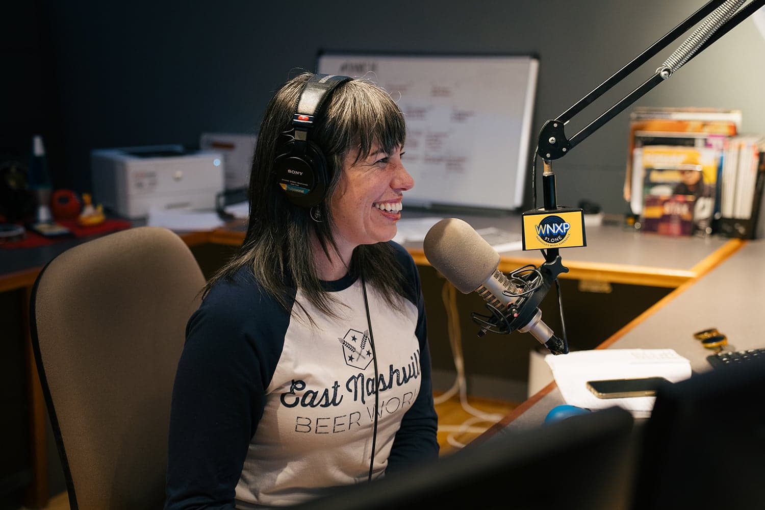 Two close-up views of microphones in radio studios, one labeled “90.3 WPLN News,” the other “WNXP 91.1 FM,” showing broadcast equipment and blurred backgrounds.